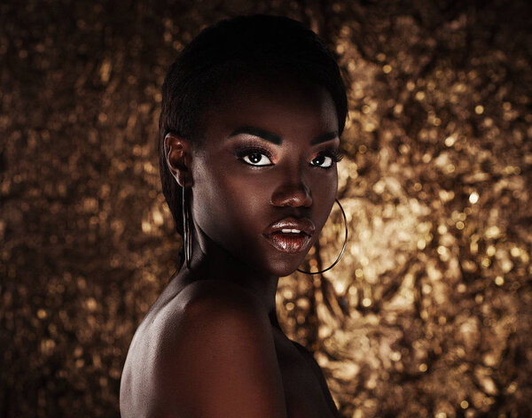 портрет чувственной молодой африканской женщины на золотом фоне
