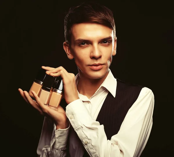 Junge männliche Visagistin posiert mit Stiftung für Make-up — Stockfoto
