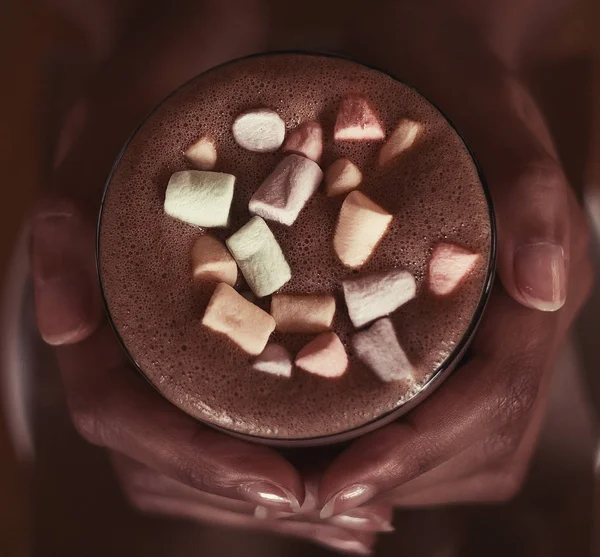 hands of an African girl holding cocoa with a marshmallow