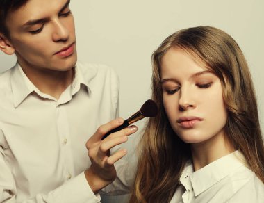 Makyöz makyaj yapıyor güzel kız, güzellik kavramı ve