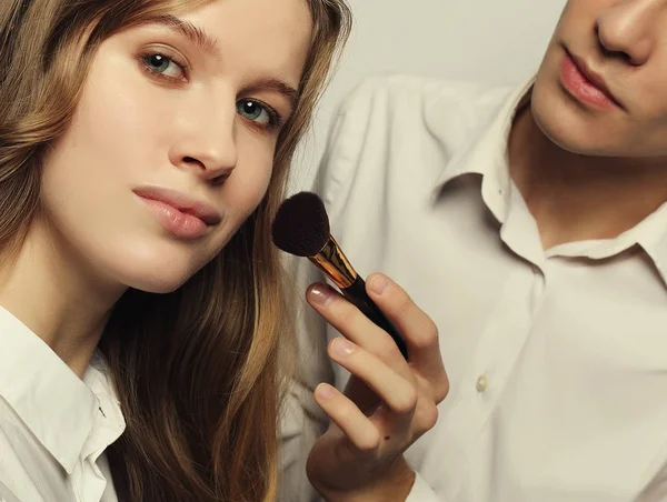 El artista de maquillaje hace maquillaje para modelo joven —  Fotos de Stock