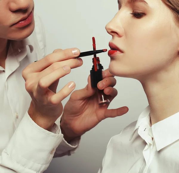 Maquillar artista haciendo profesional maquillaje de mujer joven —  Fotos de Stock