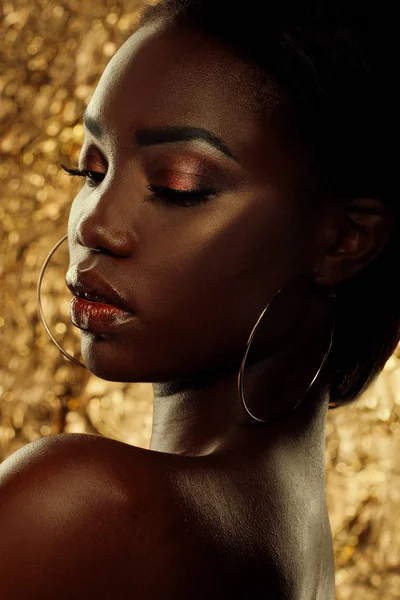 Retrato de estudio de moda de una extraordinaria hermosa modelo afroamericana con ojos cerrados sobre fondo dorado — Foto de Stock