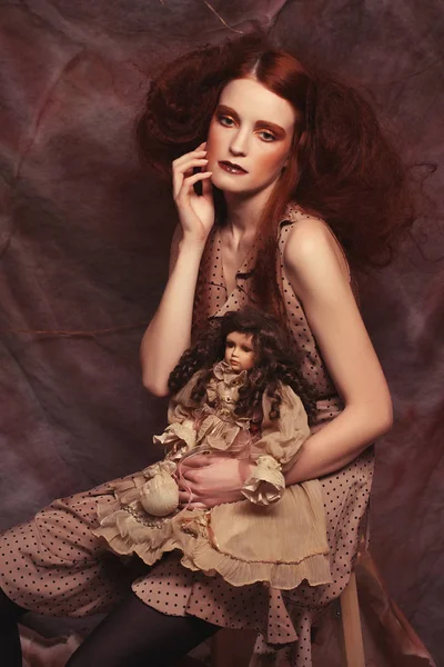 Modelo de moda joven con maquillaje creativo sentado en un taburete en —  Fotos de Stock