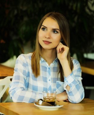 Sabahları restoranda kahve içen bir kadın.