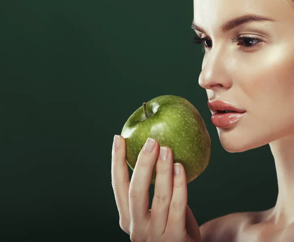 Mujer joven con manzana verde sobre fondo verde — Foto de Stock