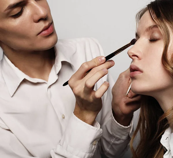 Maquillador haciendo maquillaje hermosa chica, concepto de belleza y — Foto de Stock