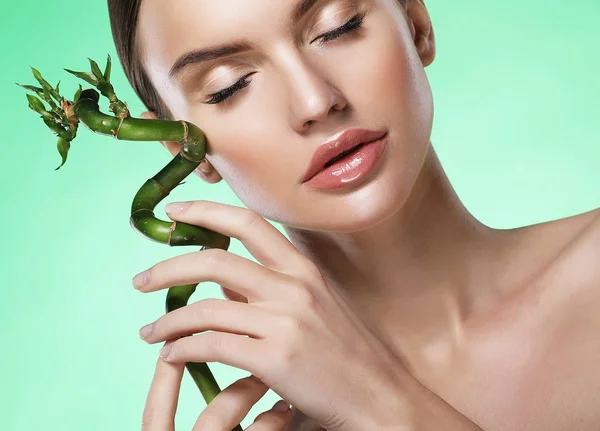 Hermosa mujer con bambú aislado sobre fondo verde — Foto de Stock