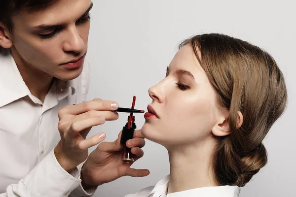 Maquillador haciendo maquillaje hermosa chica, concepto de belleza y — Foto de Stock