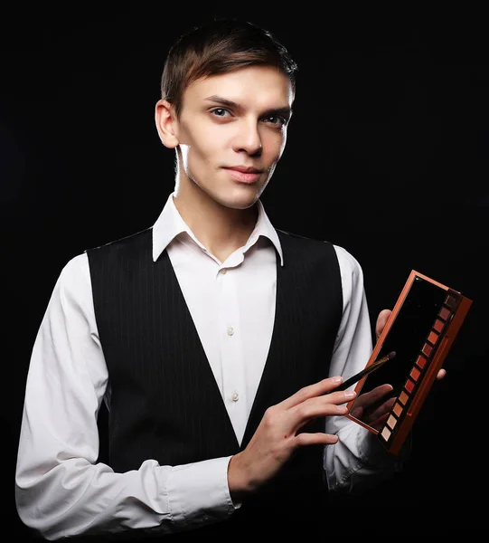 Male make-up artist  staying on dark  background, holding profes — Stock Photo, Image