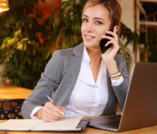 Mujer feliz utilizando el chat con el móvil y el ordenador portátil de uso — Foto de Stock