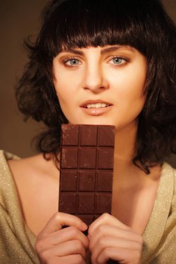 Bej renkli arka plan üzerinde çikolata ile güzel kız