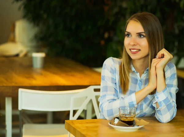Усміхнена жінка в хорошому настрої з чашкою кави, сидячи в кафе . — стокове фото