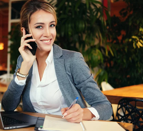 Mujer feliz utilizando el chat con el móvil y el ordenador portátil de uso — Foto de Stock