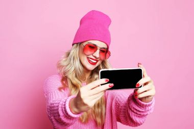 Moda kız alarak fotoğraf kendi kendine portre smartphone wea üzerinde yapar.