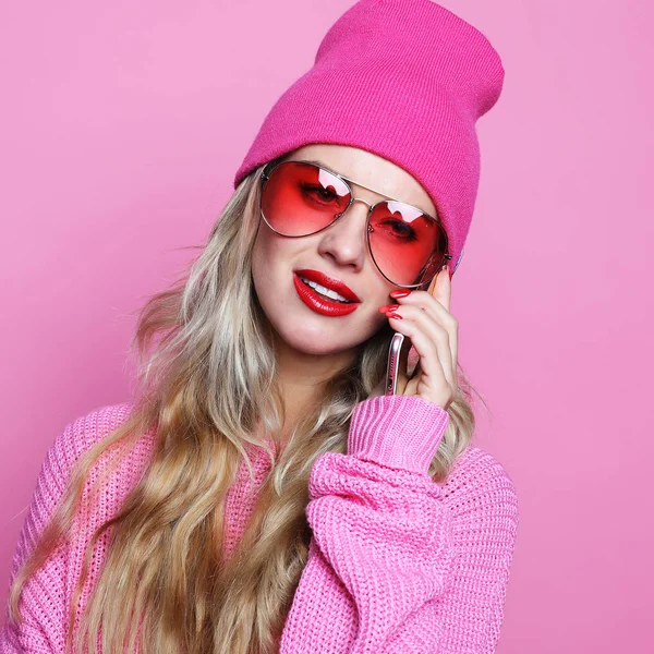 Модная счастливая крутая улыбчивая девушка, говорящая по смартфону в розовой рубашке — стоковое фото