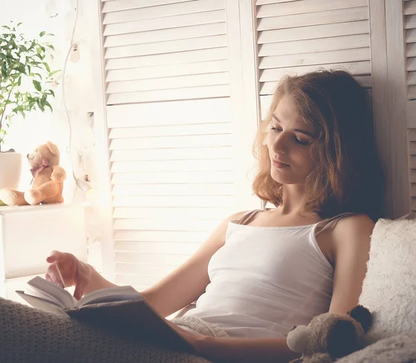Lifestyle en people concept: Jonge vrouw die in bed ligt terwijl ze leest — Stockfoto