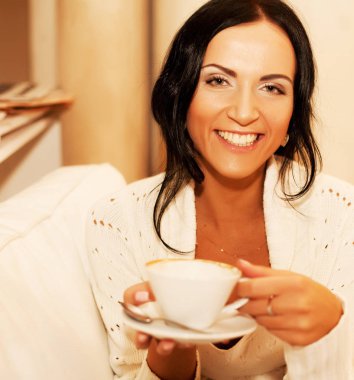 bir kupa kahve tutan kadın