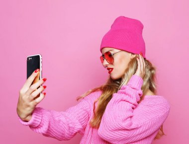 Moda kız alarak fotoğraf kendi kendine portre smartphone wea üzerinde yapar.