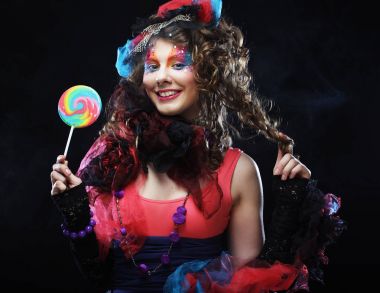 Yaratıcı makyajlı kız lolipop tutuyor. Bebek stili.