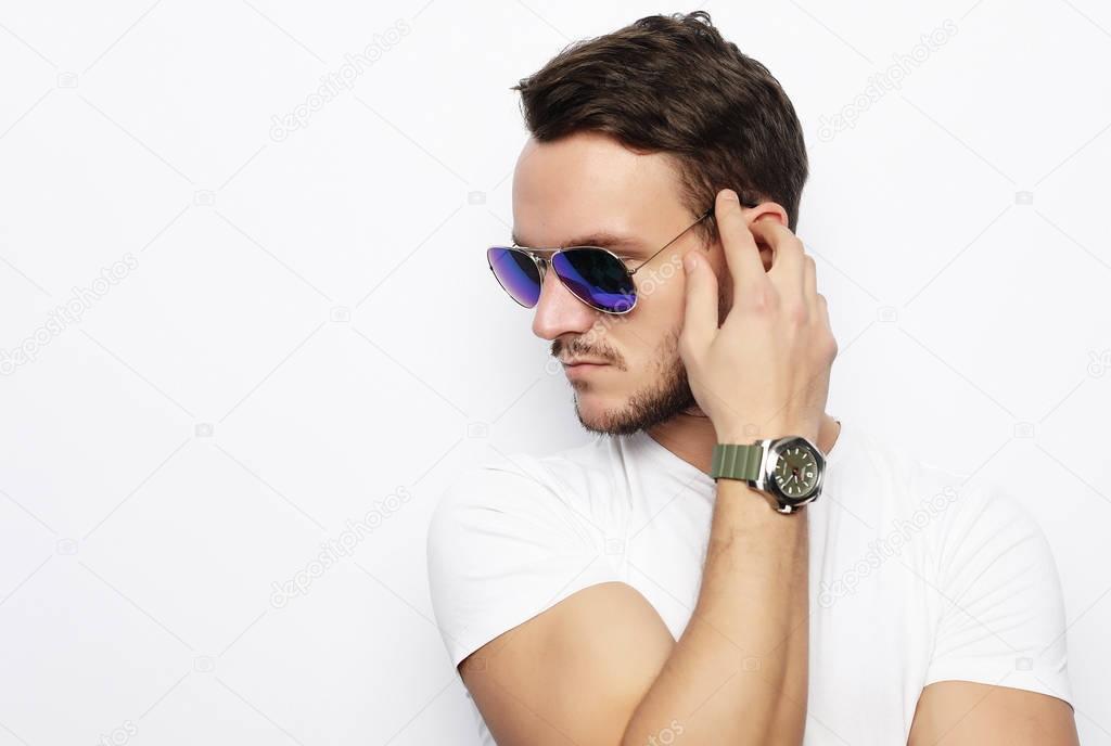 young man in smart wear, wearing fashion sunglasses against whit