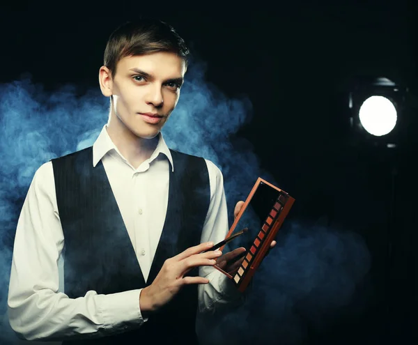 Professional makeup artist posing in studio, holds a palette of — Stock Photo, Image