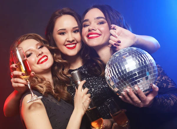 Belas mulheres jovens com copos de vinho e bola de discoteca . — Fotografia de Stock