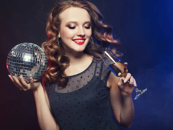 Gece kulübünde elinde şarap ve disko topu tutan genç bir kadın. — Stok fotoğraf
