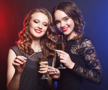 Parti zamanı. Şarap bardakları ve boksörleri olan iki güzel genç kadın.