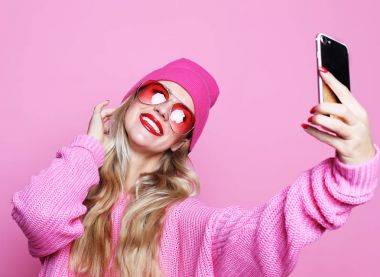 Moda kız alarak fotoğraf kendi kendine portre smartphone wea üzerinde yapar.