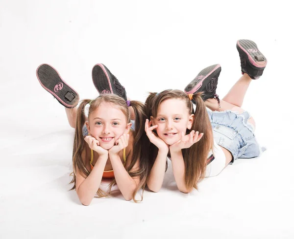 Duas meninas bonitas que colocam no branco — Fotografia de Stock