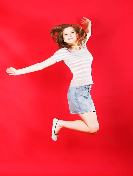Κορίτσι άλμα της χαράς πάνω από το κόκκινο — Φωτογραφία Αρχείου