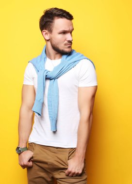 Sarı arka planda izole bir şekilde duran genç adamın resmi. Ben...