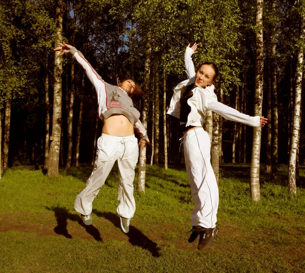Två flickor hoppa i park — Stockfoto