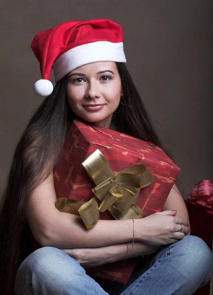 Hermosa mujer joven con sombrero de Santa Claus con presente — Foto de Stock