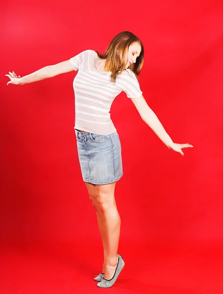 Mulher atraente pulando de alegria sobre vermelho — Fotografia de Stock