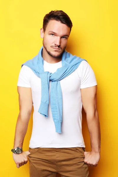 Young man in smart casual wear looking at camera over yellow bac — Stock Photo, Image