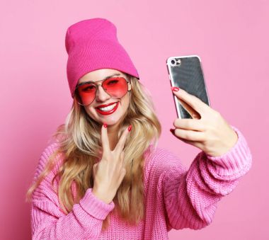 Moda kız alarak fotoğraf kendi kendine portre smartphone wea üzerinde yapar.