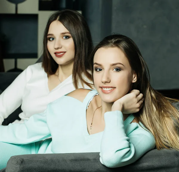 Deux amis souriants assis sur le canapé regardant la caméra dans le salon à la maison — Photo