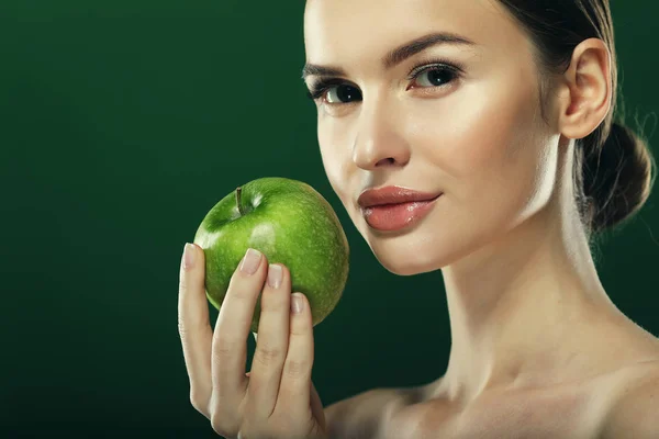 Mladá žena se zeleným jablkem přes zelené pozadí — Stock fotografie