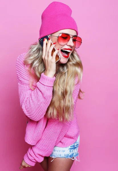 Модная счастливая крутая улыбчивая девушка, говорящая по смартфону в розовой рубашке — стоковое фото