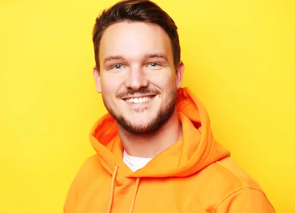 Smarta unga leende man står mot gul bakgrund — Stockfoto