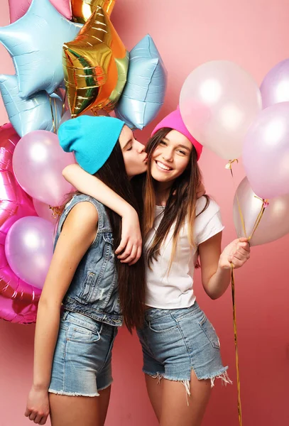 Two pretty emotional girls hold balloons and posing against pin — Stock Photo, Image