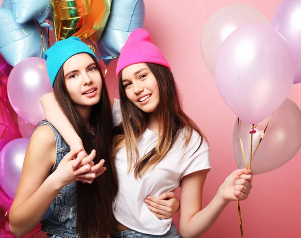 Красивые девушки с воздушными шарами на розовом фоне — стоковое фото