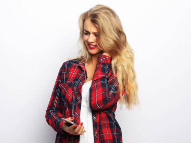 Beyazlar yerine akıllı telefondan müzik dinleyen mutlu genç kadın.