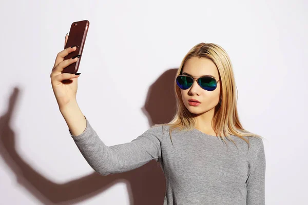Vacker hipster flicka gör selfie över vit bakgrund. — Stockfoto