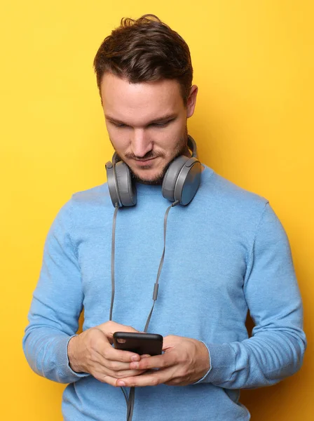 Hombre guapo lamiendo música sobre fondo amarillo — Foto de Stock