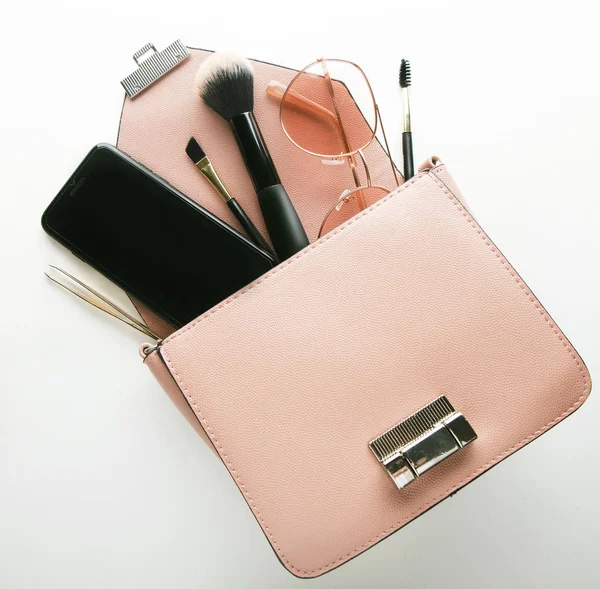 Flat lay of pink leather woman bag open out with cosmetics, acce — Stock Photo, Image