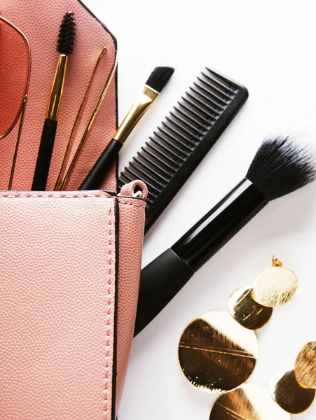 Kozmetik ürünler ve Acce ile açılmış pembe deri kadın çantası.