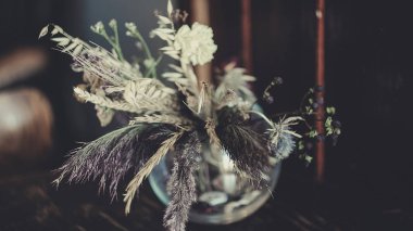 Masanın üzerinde kurumuş çiçekler var.